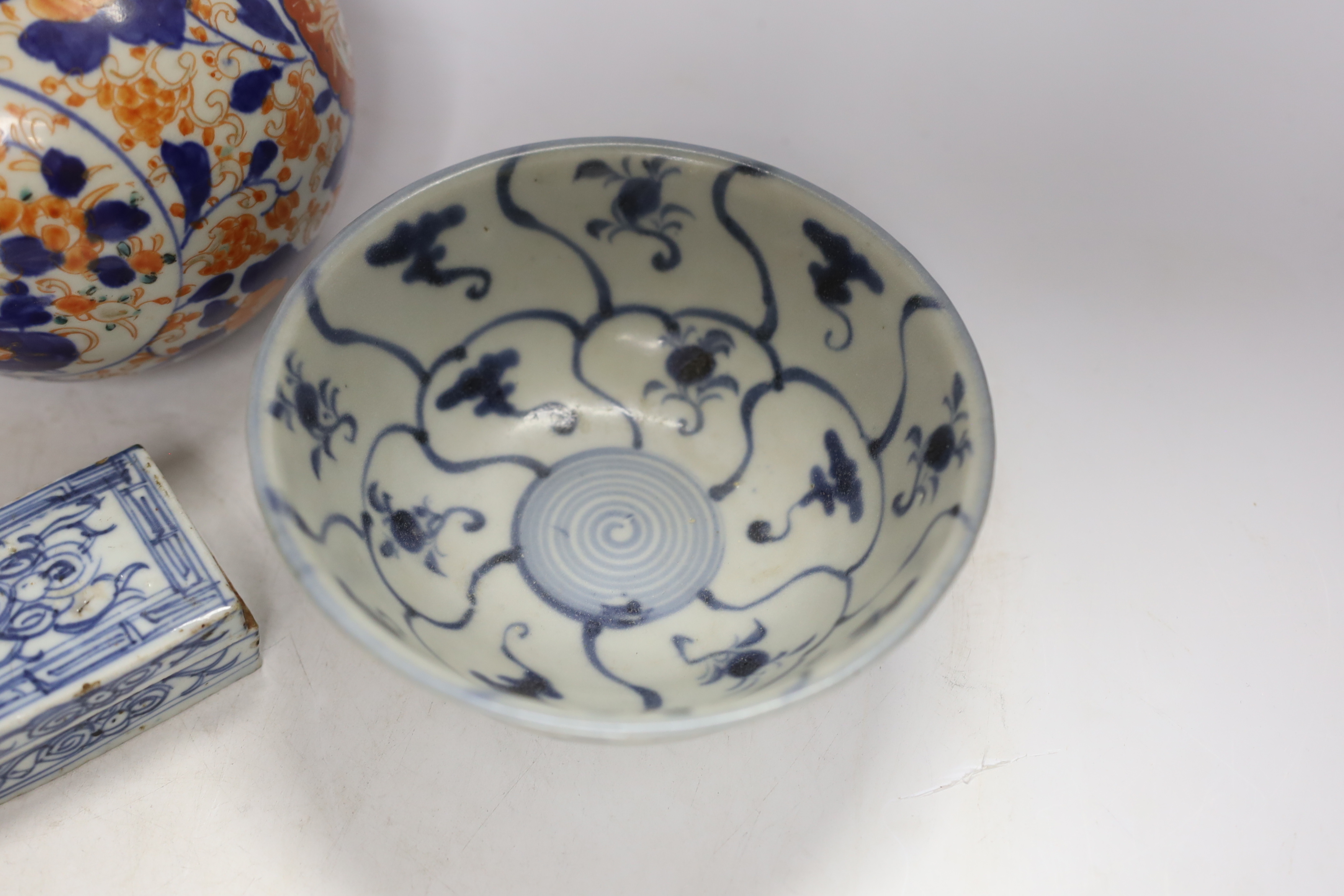 A Chinese Tek Sing Cargo bowl, a Chinese famille Rose Jar and cover, late 19th century, a stem cup with hidden decoration a box and cover and a Japanese Imari bottle vase.